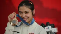 Peraih medali perunggu cabang olahraga bulu tangkis tunggal putri Olimpiade Paris 2024, Gregoria Mariska Tunjung berfoto dengan medali yang diraihnya di Istana Merdeka, Jakarta, pada Kamis 15 Agustus 2024. (BAY ISMOYO/AFP)