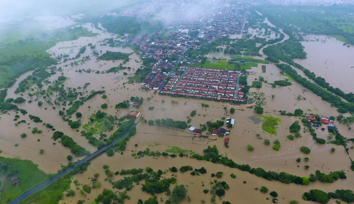 Pemandangan dari udara banjir akibat hujan lebat di Itapetinga, Negara Bagian Bahia, Brasil, 26 Desember 2021. Korban tewas akibat hujan lebat yang melanda Bahia sejak November lalu meningkat menjadi 18 orang. (Manuella LUANA/AFP)