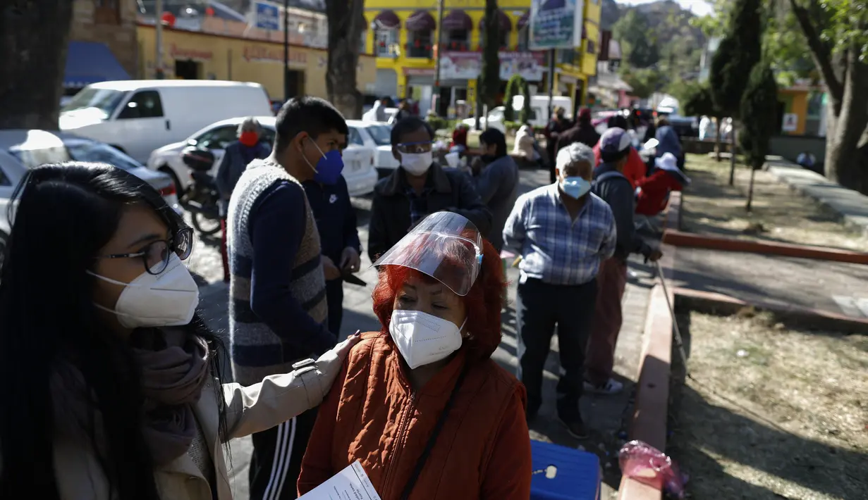 Para lansia di atas 60 tahun menunggu untuk menerima vaksin Covid-19 AstraZeneca di luar pusat kesehatan di wilayah terpencil Milpa Alta di Mexico City, Senin (15/2/2021). Meksiko pada Senin (15/2) mulai melakukan vaksinasi massal Covid-19 pada jutaan warga lanjut usia. (AP/Rebecca Blackwell