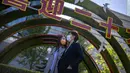 Orang-orang berjalan melewati pajangan yang menandai Kongres Nasional ke-20 Partai Komunis China yang akan datang, di Beijing, Selasa (11/10/2022). Perjalanan turun selama liburan Hari Nasional tahunan yang dimulai 1 Oktober, karena pihak berwenang melarang orang meninggalkan kota dan provinsi mereka. (AP Photo/Mark Schiefelbein)