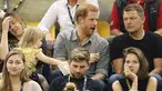 Seorang bocah, Emily Henson diam-diam mengambil popcorn Pangeran Harry yang sedang berbincang dengan rekannya ketika acara Invictus Games di Toronto, Rabu (27/9). Kejadian tertangkap kamera ini begitu menggemaskan. (CHRIS JACKSON/GETTY IMAGES/AFP)