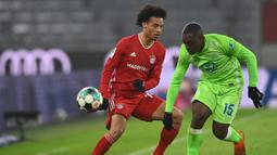 Gelandang Bayern Munchen, Leroy Sane, berebut bola dengan bek Wolfsburg, Jerome Roussillon, pada laga lanjutan Liga Jerman di Allianz Arena, Kamis (17/12/2020) dini hari WIB. Bayern Munchen menang 2-1 atas Wolfsburg. (AFP/Christof Stache/pool)