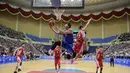 Pemain Korea Utara (merah) berusaha memblok bola dari serangan pemain Korea Selatan (biru) selama pertandingan basket pria ramah di Stadion Indoor Ryugyong Chung Ju-Yung, Pyongyang (5/7). Tim pria Korea Utara memenangkan 82-70. (AFP Photo/Kim Won-Jin)