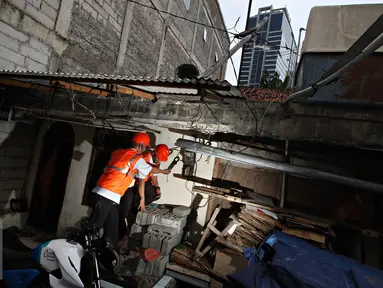 Petugas PLN Distribusi Jakarta Raya memeriksa tegangan pada alat pembatas dan pengukur di, Jakarta, Selasa (17/11). Pemerintah memutuskan tetap memberikan subsidi listrik pada seluruh pelanggan PLN dengan daya 450 VA. (Liputan6.com/Immanuel Antonius)