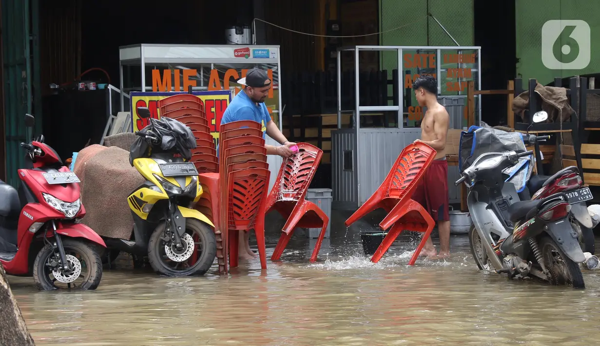Pedagang membersihkan bangku di Kawasan pertokoan Jalan KH Hasyim Ashari, Ciledug, Tangerang, Kamis (2/1/2020). Banjir yang melanda Ciledug dan sekitarnya membuat aktivitas perekonomian di kawasan tersebut lumpuh sementara. (Liputan6.com/Angga Yuniar)