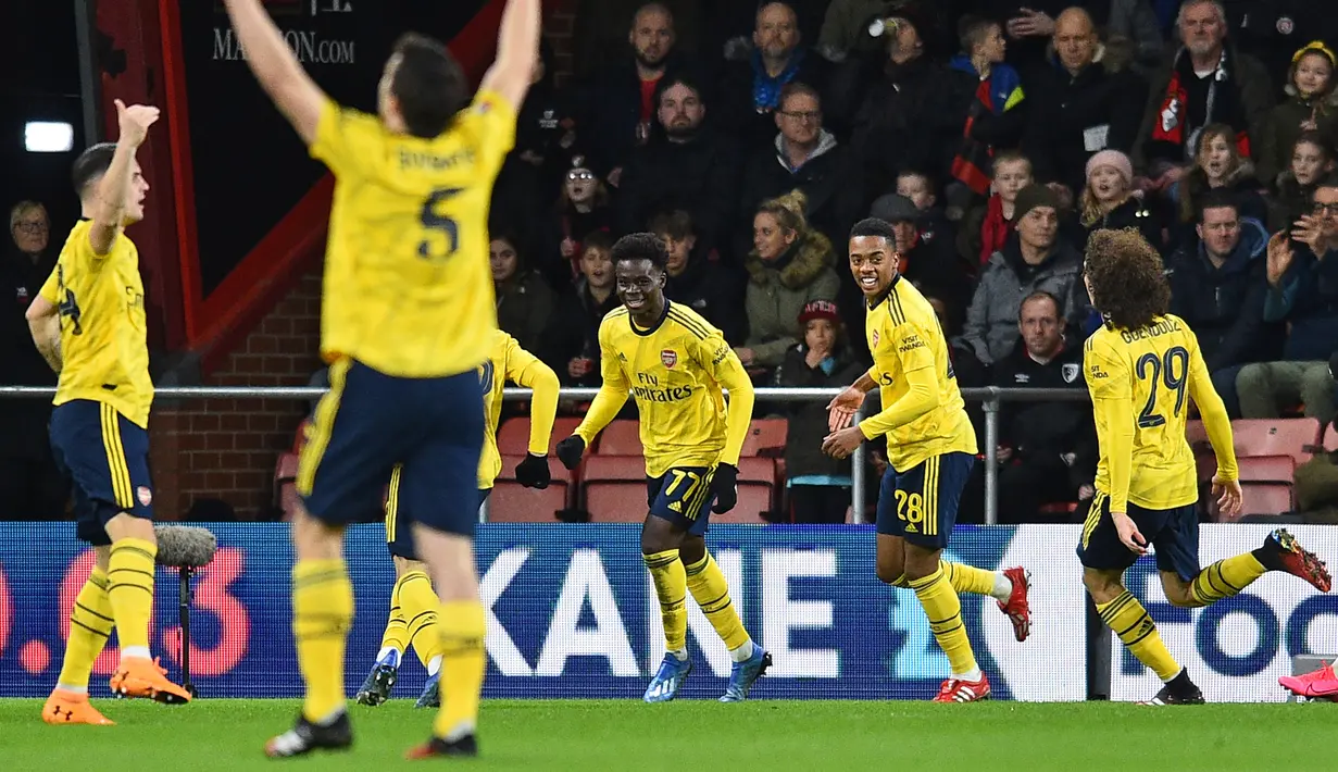 Penyerang Arsenal, Bukayo Saka (tengah) berselebrasi dengan rekan-rekannya usai mencetak gol ke gawang Bournemouth pada pertandingan putaran keempat Piala FA di Stadion Vitalitas di Bournemouth, Inggris (27/1/2020).  Arsenal menang tipis 2-1 atas Bournemouth. (AFP Photo/Glyn Kirk)