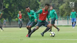 Pemain Timnas Indonesia U-23, Irfan Jaya (kiri) berebut bola dengan Osvaldo Haay saat latihan di Lapangan A Senayan, Jakarta, Sabtu (17/3). Latihan ini persiapan uji tanding melawan Singapura pada 21 Maret mendatang. (Liputan6.com/Helmi Fithriansyah)