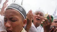 Ekspresi peserta aksi saat berdoa bersama dalam aksi Reuni 212, Jakarta, Sabtu (2/12). Aksi yang diselenggarakan sebagai bentuk reuni kegiatan 2 Desember 2016 itu diisi dengan pembacaan zikir, salawat serta salat berjamaah. (Liputan6.com/Herman Zakharia)