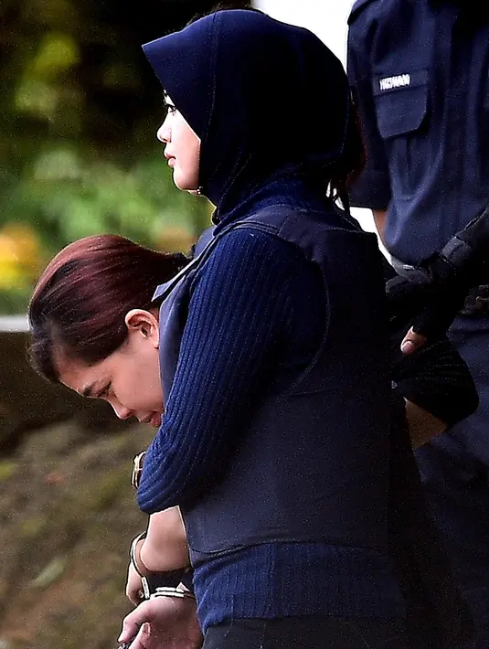 Terdakwa warga Indonesia, Siti Aisyah dikawal oleh polisi masuk ke Gedung Mahkamah Sepang, Selangor, Kamis (13/4). Sidang kedua kasus pembunuhan saudara pemimpin Korea Utara, Kim Jong-nam di bawah penjagaan ketat aparat keamanan. (MOHD RASFAN/AFP)
