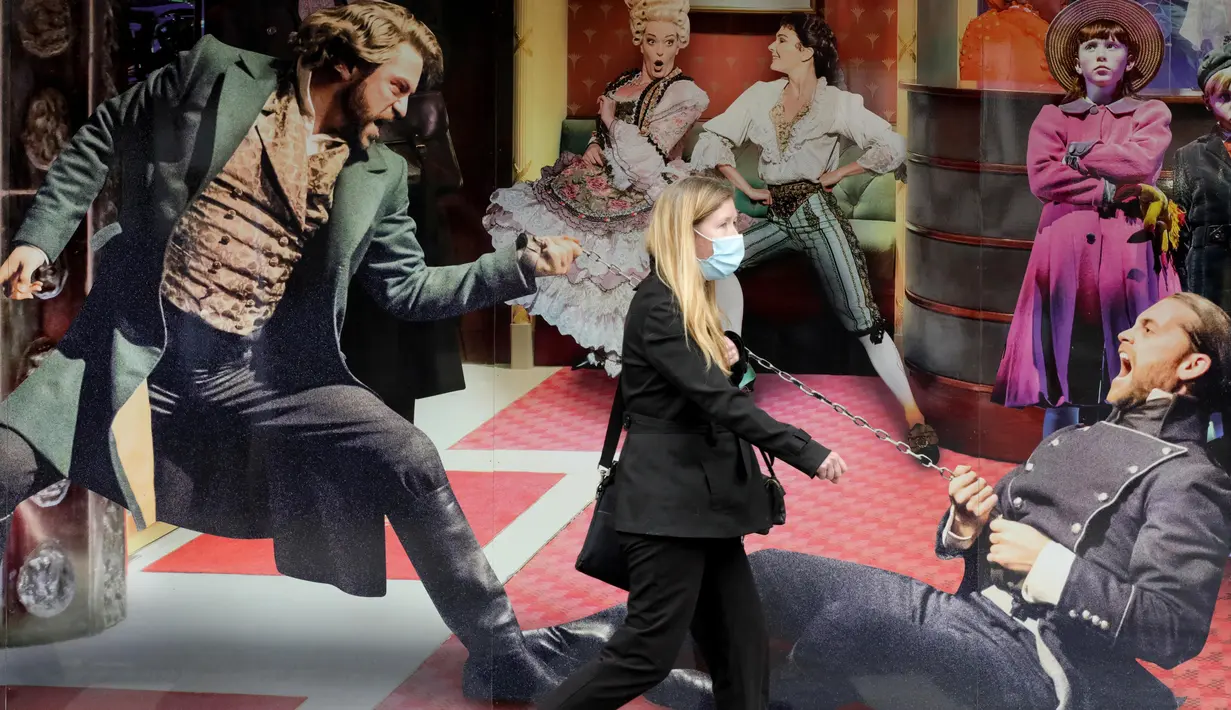 Wanita berjalan melewati poster Les Miserables di Sondheim Theatre, London, Inggris, Selasa (7/7/2020). Pemerintah Inggris akan menyalurkan paket bantuan sebesar 1,57 miliar poundsterling kepada industri seni, budaya, dan warisan untuk membantu mengatasi dampak pandemi COVID-19. (Xinhua/Tim Ireland)