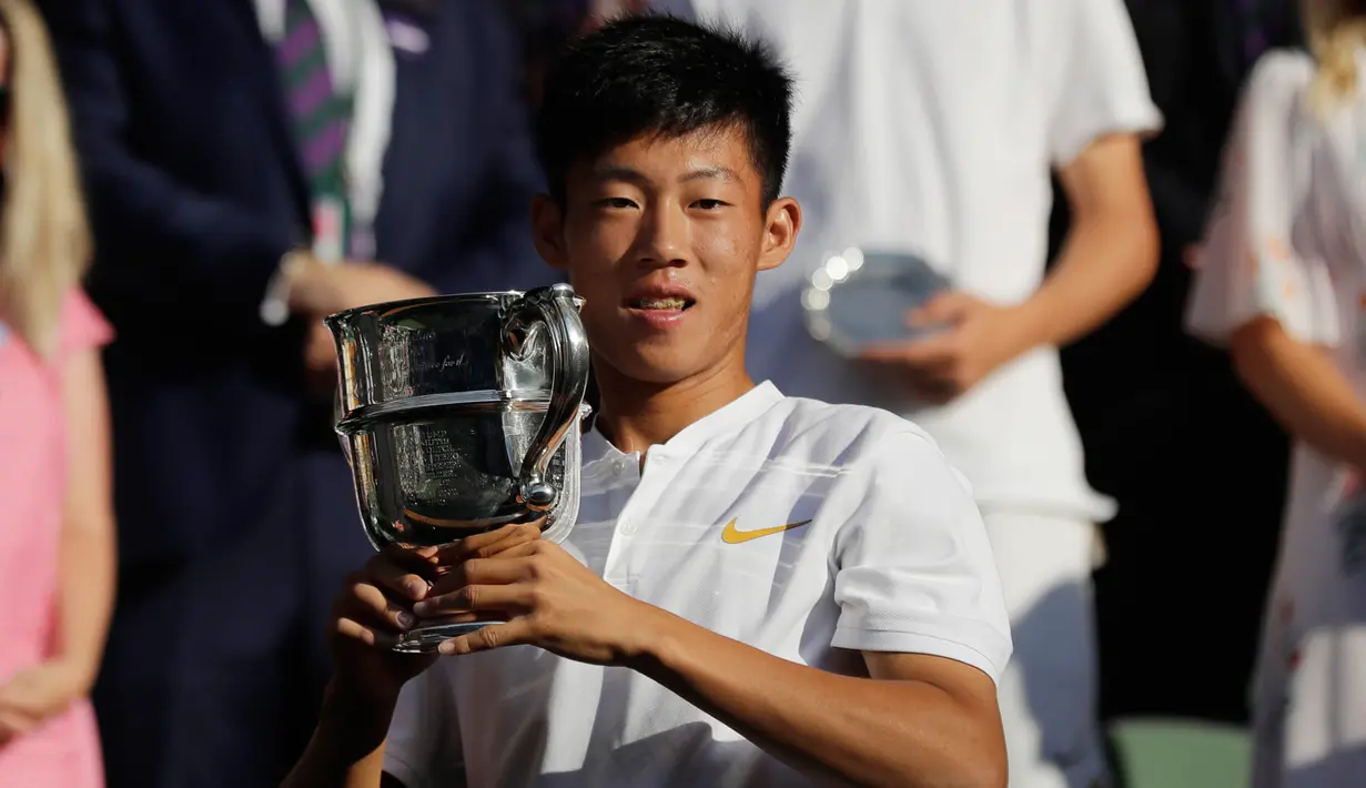 Petenis Taiwan Tseng Chun Hsin berpose dengan trofi usai mengalahkan Jack Draper dari Inggris di final tunggal putra Kejuaraan Tenis Wimbledon Junior di London, (15/7). Petenis 16 tahun ini menang dengan skor 6-1, 6-7 (2/7), dan 6-4. (AP Photo/Ben Curtis)
