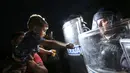 Seorang anak imigran di depan polisi Slovenia yang menghadang mereka di Harmica, Kroasia (18/9/2015). (REUTERS / Srdjan Zivulovic)