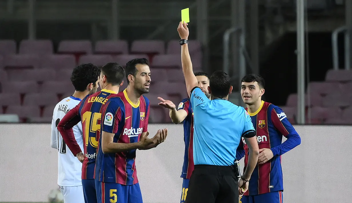 Wasit Jorge Figueroa Vazquez memberi kartu kuning kepada bek Barcelona, Clement Lenglet (kedua dari kiri) dalam laga lanjutan Liga Spanyol 2020/2021 pekan ke-32 di Camp Nou Stadium, Barcelona, Kamis (22/4/2021). Barcelona menang 5-2 atas Getafe. (AFP/Lluis Gene)