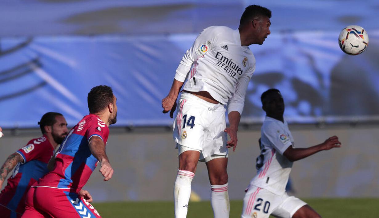 Gelandang Real Madrid, Casemiro, menyundul bola saat melawan Elche pada laga Liga Spanyol di Stadion Alfredo di Stefano, Sabtu (13/3/2021). Real Madrid menang dengan skor 2-1. (AP/Bernat Armangue)
