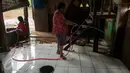 Warga membersihkan rumahnya di Jalan Taman Harapan rt 02/03, Kramat Jati, Jakarta, Senin (13/2). Hujan yang turun sepekan ini, mengakibatkan puluhan rumah warga disekitar sungai Ciliwung terendam banjir setinggi 1 meter. (Liputan6.com/Gempur M Surya)