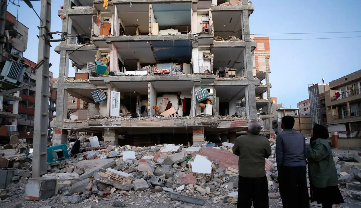 Warga melihat bangunan yang hancur akibat gempa 7.3 SR di Sarpol-e Zahab, Provinsi Kermanshah, Iran, (13/11). Gempa dahsyat di perbatasan Irak-Iran ini menewaskan ratusan orang dan melukai 1.600 lainnya. (Pouria Pakizeh/ISNA via AP)