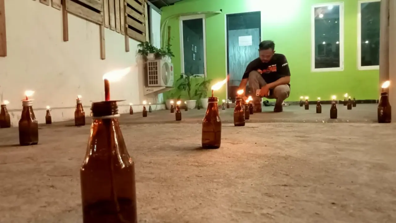 Puluhan pelita dinyalakan di halaman rumah warga Gorontalo di Kota Palu. Tradisi itu dilakukan di malam ke-27 Ramadan. (Foto: Heri Susanto/ Liputan6.com).
