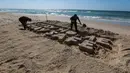 Para seniman Palestina mengukir kata "TETAP DI RUMAH TETAP AMAN" dengan pasir di sebuah pantai di Gaza City pada 12 April 2020. Palestina pada Minggu (12/4) melaporkan jumlah total kasus COVID-19 di negara tersebut telah mencapai 290. (Xinhua/Rizek Abdeljawad)