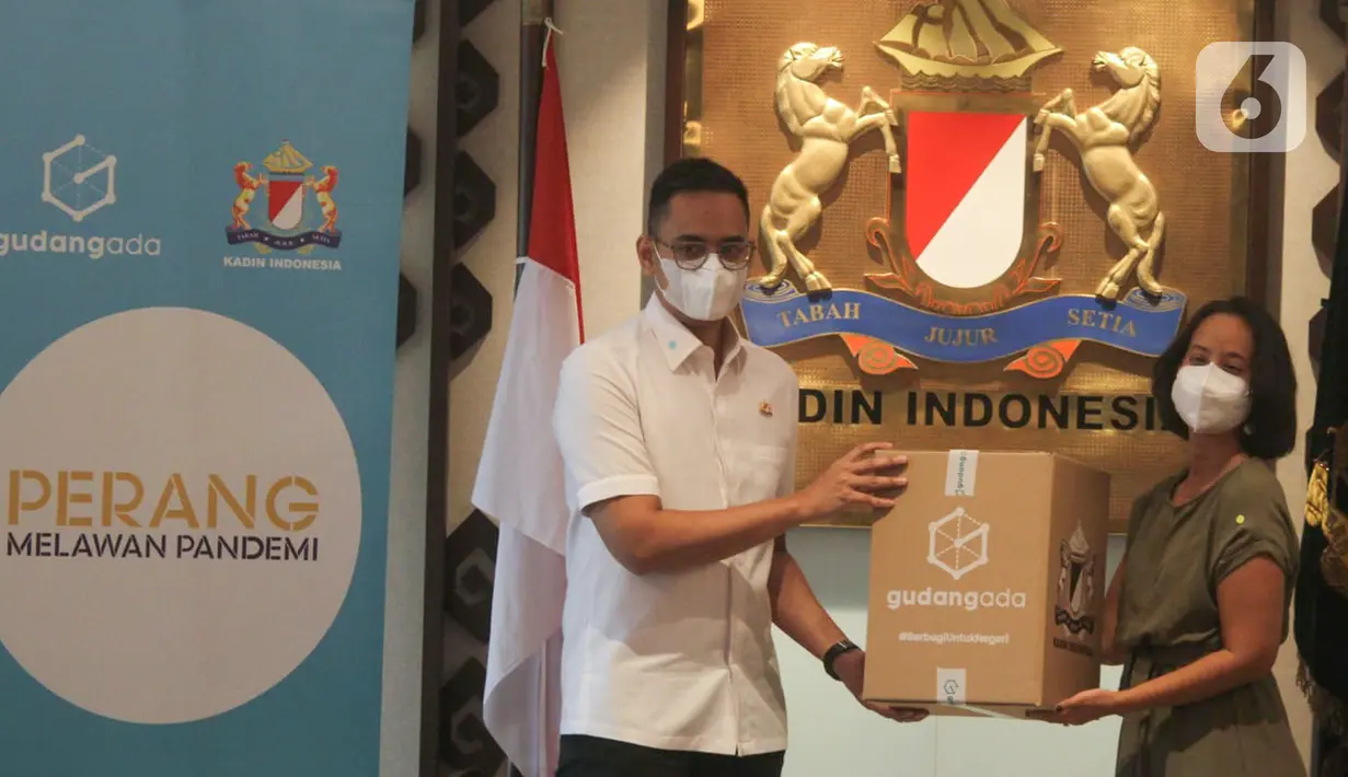 Senior Communication Manager GudangAda, Muara Makarim (kanan) secara simbolis menyerahkan paket sembako kepada Ketua Pelaksana Vaksinasi Keliling yang juga Wakil Ketua Umum Bidang Komunikasi dan Informatika KADIN Firlie H (kiri) di Jakarta, Senin (11/10/2021). (Liputan6.com/HO/Agus)