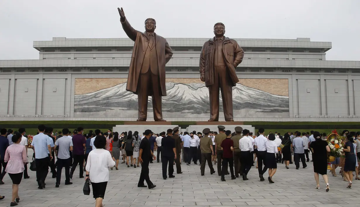 Sejumlah warga mengunjungi Mansu Hill untuk memberi penghormatan terhadap patung-patung perunggu dari Kim Il-sung dan Kim Jong-il pada peringatan 26 tahun kematian Kim Il-sung di Pyongyang, Korea Utara, Rabu (8/7/2020). (AP Photo/Cha Song Ho)
