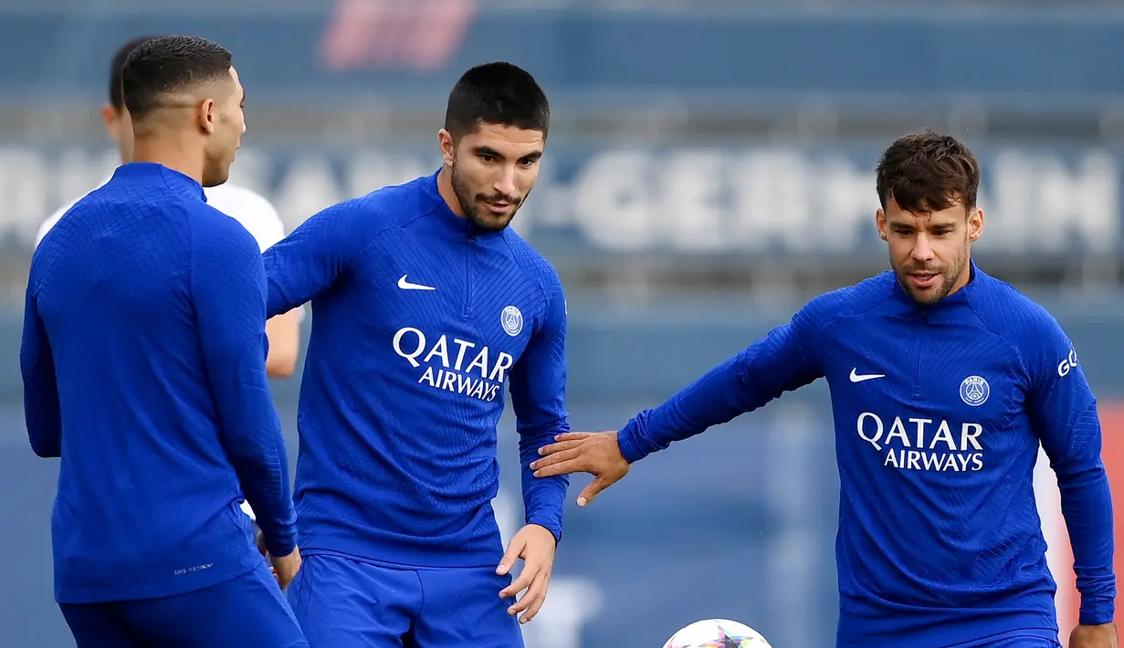 <p>Bek Paris Saint-Germain (PSG) Juan Bernat berebut bola dengan Carlos Soler (tengah) dalam sesi latihan di Saint-Germain-en-Laye di luar Paris, Senin (5/9/2022). PSG akan menjamu Juventus pada matchday 1 Grup H Liga Champions 2022/2023 di Parc des Princes, Rabu 7 September 2022 dini hari. (Photo by FRANCK FIFE / AFP)</p>