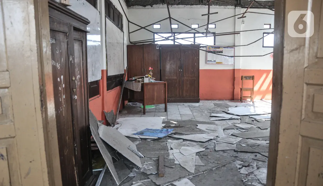 Kondisi ruang kelas yang rusak akibat terjangan angin kencang di Sekolah Dasar Negeri (SDN) Pancoranmas 3, Depok, Jawa Barat, Minggu (24/7/2022). Puing-puing sisa bangunan yang ambruk pun masih berserakan di ruang kelas. (merdeka.com/Iqbal S. Nugroho)
