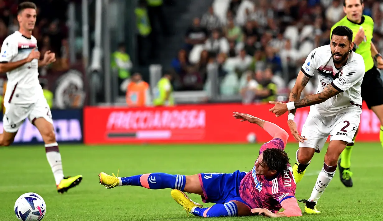 Pemain depan Juventus, Dusan Vlahovic (tengah) berebut bola dengan gelandang Salernitana Dylan Bronn pada pekan keenam Liga Italia Serie A musim 2022/2023 di Allianz Stadium, Senin (12/8/2022) dini hari WIB.  Juventus harus puas hanya bermain imbang 2-2 kala menjamu Salernitana. (Photo by Isabella BONOTTO / AFP)