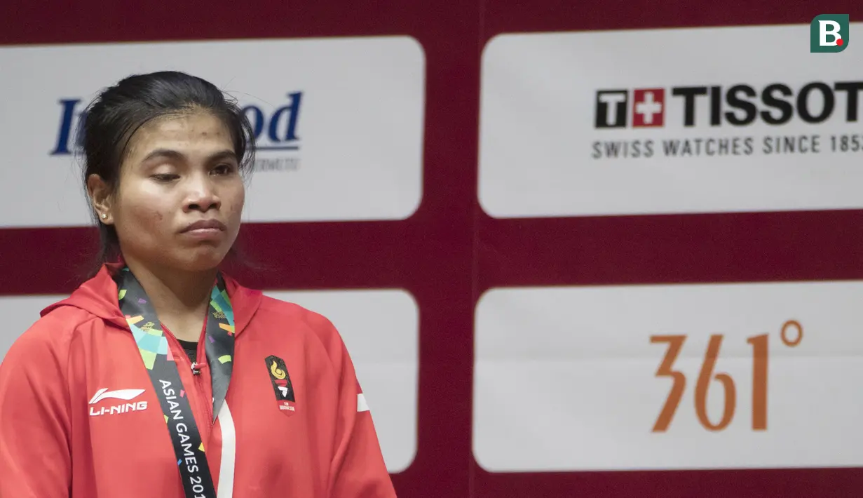 Atlet angkat besi, Sri Wahyuni, tampak lesu usai berlaga pada Asian Games di JIExpo, Jakarta, Senin, (20/8/2018). Sri Wahyuni menyumbang medali perak dengan total angkatan 195 kg. (Bola.com/Vitalis Yogi Trisna)