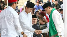 Yusril Ihza Mahendra menyalami Sandiaga Uno saat bertemu di acara Gebyar Budaya Betawi di Balai Rakyat Condet, Jakarta, Minggu (20/3/2016). Dua balon Gubernur DKI Jakarta tersebut menemui Rumpun Masyarakat Betawi. (Liputan6.com/Yoppy Renato)