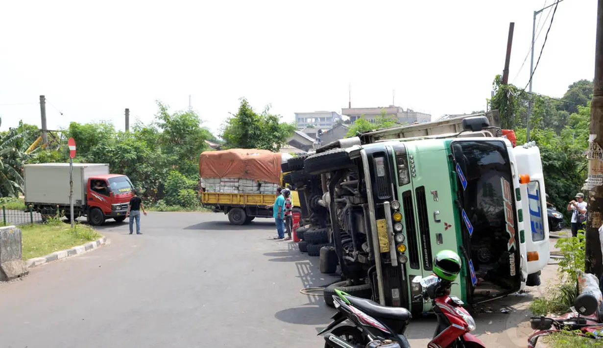 Kendati demikian, terbaliknya truk tak membuat arus kendaraan di jalan tersebut macet, mengingat posisi badan kenderaan itu terbalik di pinggir jalan, Jakarta, Jumat (15/8/14). (Liputan6.com/Panji Diksana)