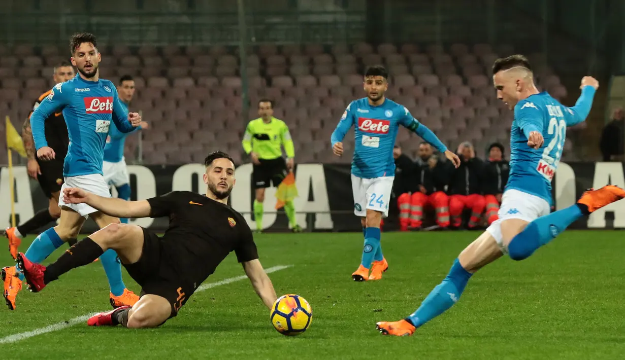Pemain tengah Napoli Piotr Zielinski menendang bola dan dihadang bek AS Roma menendang bola saat pertandingan Liga Italia Serie A di stadion San Paolo di Naples, Italia (3/3). (AFP Photo/Carlo Hermann)