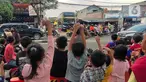 Sejumlah anak berjoget sambil merekam fenomena klakson bus telolet yang kembali marak di Jalan Raya Ciledug, Tangerang, Minggu (18/6/2023). (Liputan6.com/Angga Yuniar)