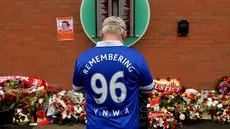 1.	Seorang suporter Everton berdoa di depan dinding bertuliskan daftar korban Tragedi Hillsborough saat peringatan 26 tahun Tragedi Hillsborough di Stadion Anfield