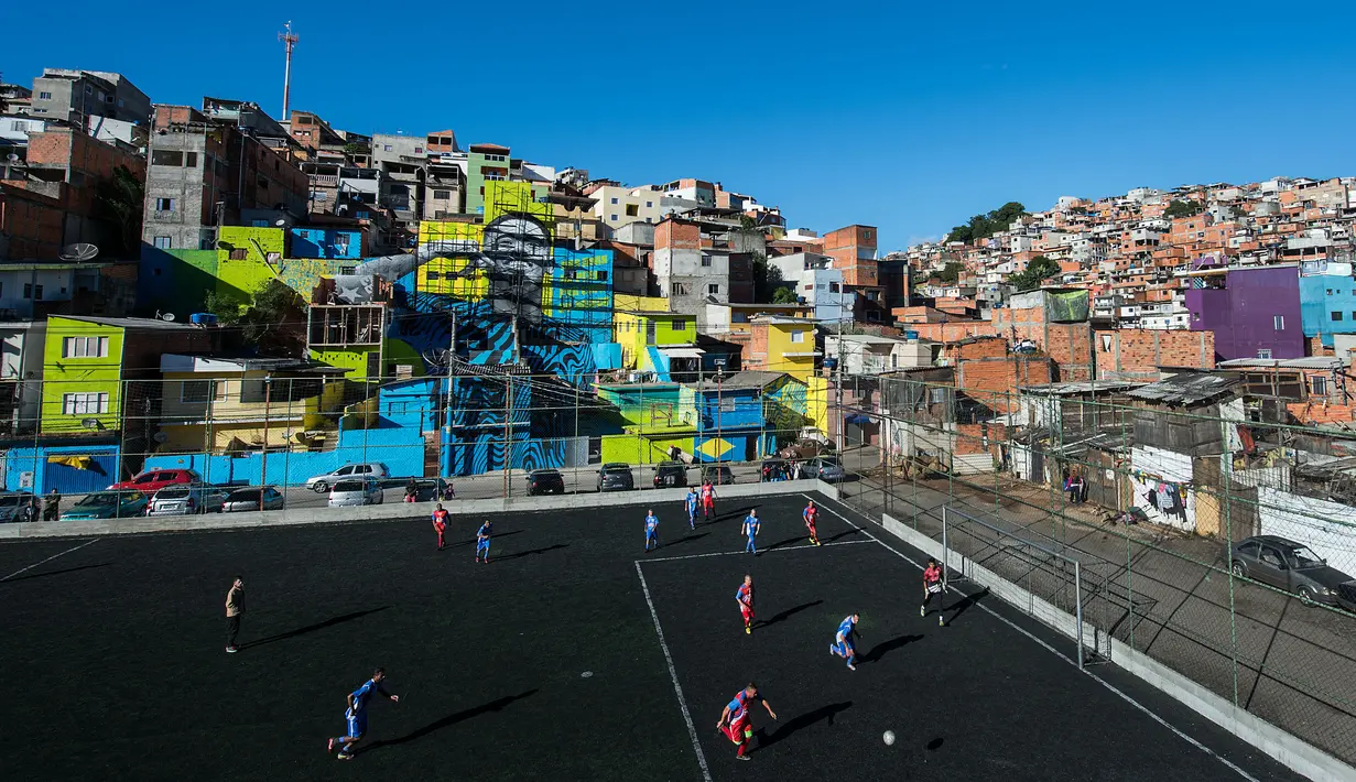 Dinding rumah yang berwana-warni menghiasi lapangan sepak bola di daerah Perus, Sao Paulo. Lapangan sepak bola tersebut tepat berada dimana pemain Manchester City, Gabriel Jesus tinggal selama masa kecilnya. (AFP/Nelson Almeida)