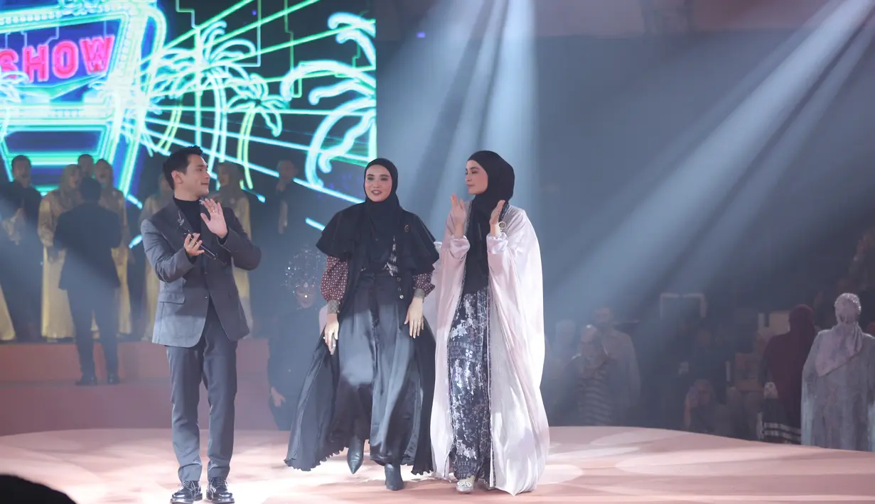 Zaskia Sungkar bergaya maskulin dengan busana bernuansa hitam merah. Ia memadukan atasan bermotif dengan cape ruffle dan celana kulot satin