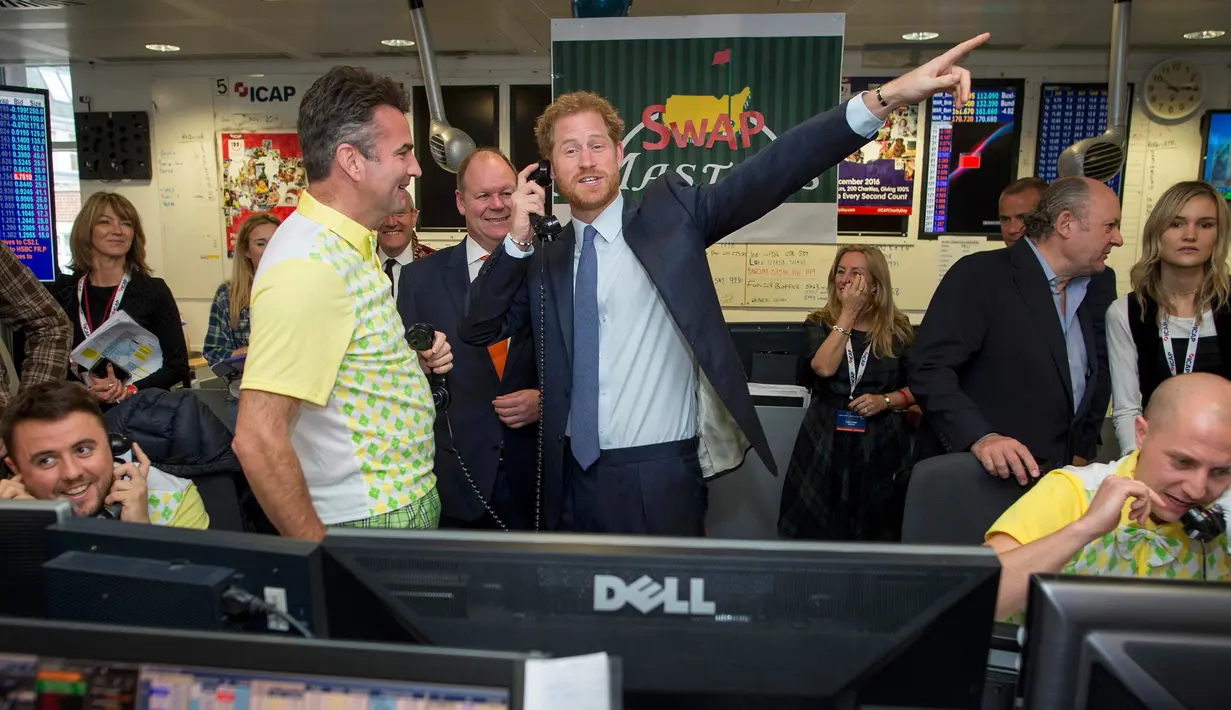 Pangeran Harry bereaksi sambil mengangkat telepon saat menjadi broker dalam acara amal tahunan ICAP di London, Rabu (7/12). Pangeran Harry menjadi broker dadakan untuk mengumpulkan dana amal dari 60 kantor di seluruh dunia. (REUTERS/Geoff Pugh/Pool)