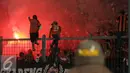 Suporter menyalakan flare saat menyaksikan laga Persija melawan Sriwijaya FC pada lanjutan Torabika Soccer Championship presented by IM3 Ooredoo di Stadion GBK Jakarta, Jumat (24/6).Laga dihentikan di menit 81. (Liputan6.com/Helmi Fithriansyah)