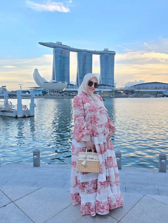 Syahrini tampil chic pakai dress bernuansa merah muda yang ia padukan mengenakan hijab cokelat muda polos, sunglasses, dan tas Hermesnya. [Foto: Instagram/princessyahrini]