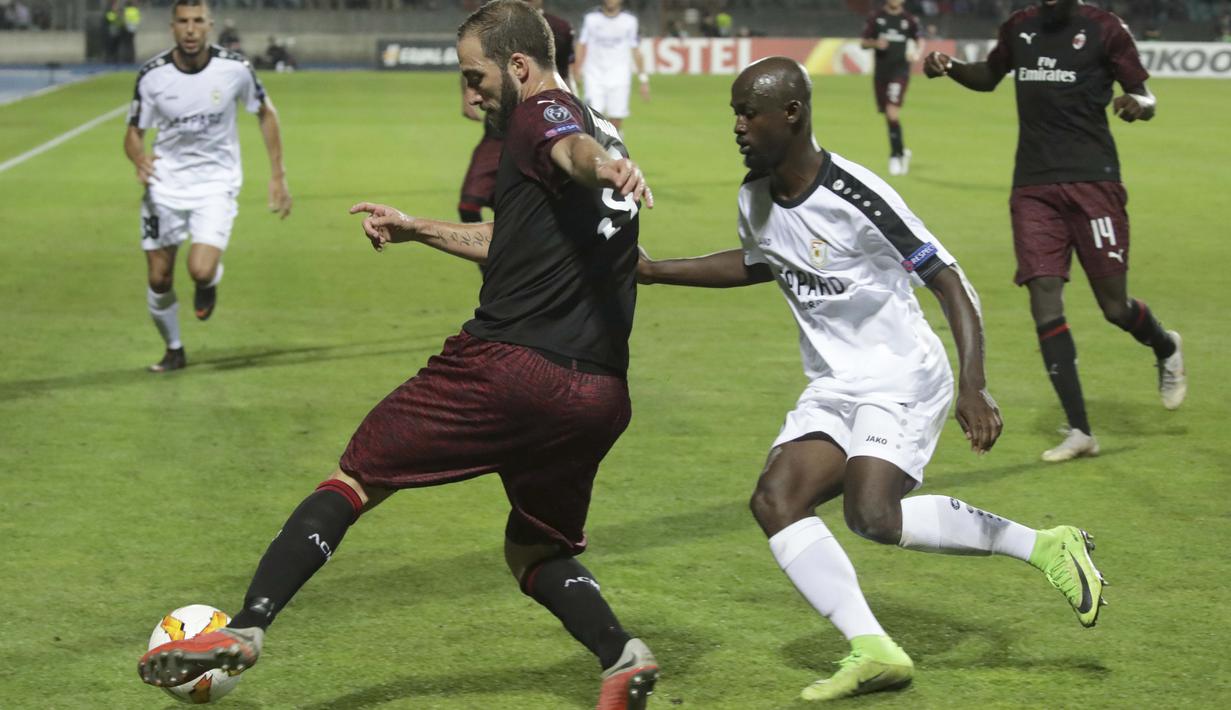 Striker AC Milan, Gonzalo Higuain, berusaha melewati pemain F91 Dudelange, Jerry Prempeh, pada laga Liga Europa di StadionJosy Bathel, Letzebuerg, Kamis (20/9/2018). AC Milan menang 1-0 atas F91 Dudelange. (AP/Olivier Matthys)