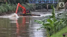 Petugas Dinas Lingkungan Hidup DK Jakarta melakukan pengerukan di sepanjang aliran Banjir Kanal Barat, Jakarta, Sabtu (1/2/2025). (Liputan6.com/Angga Yuniar)