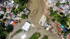 Foto udara menunjukkan pemandangan rumah-rumah penduduk dan jalan yang terendam air akibat luapan sungai sebagai dampak longsornya tumpukan sampah yang menyumbat aliran sungai di Depok pada 7 Mei 2024. (BAY ISMOYO/AFP)