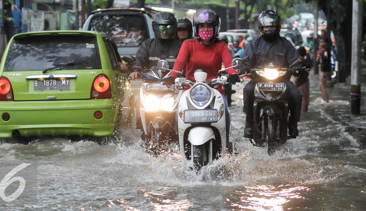 Pengendara motor menerobos genangan air di Pejaten Raya, Jakarta, Selasa (4/10). Akibat curah hujan yang tinggi menyebabkan sejumlah titik di Jakarta tergenang air. (Liputan6.com/Yoppy Renato)