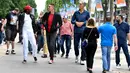 Sejumlah pria tertinggi di dunia berjalan di tengah keramaian di Champs-Elysees Avenue, Paris, 1 Juni 2018. Belasan pria tertinggi di dunia bertemu pada akhir pekan di ibu kota Prancis. (AFP/GERARD JULIEN)