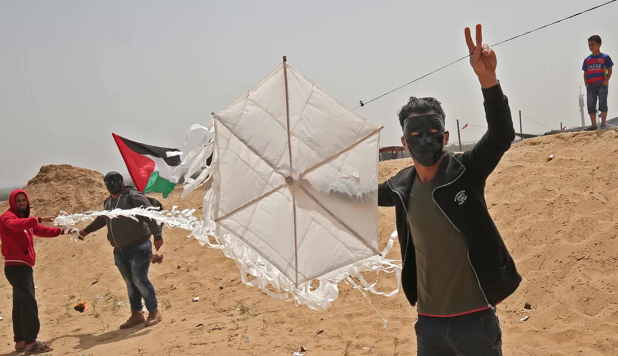 Warga Palestina bersiap menerbangkan layang-layang yang telah diberikan bom molotov di atas pagar perbatasan dengan Israel, di pinggiran timur Kota Gaza (20/4). Unjuk rasa warga Palestina terhadap Isrel memasuki minggu keempat. (AFP Photo/Mohammed Abed)