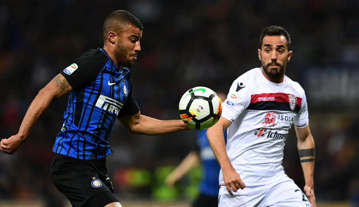 Pemain Inter Milan, Rafinha berebut bola dengan pemain Cagliari, Marco Sau pada laga pekan ke-33 Serie A, di Giuseppe Meazza, Selasa (17/4).  Menjamu Cagliari, Inter Milan memetik kemenangan meyakinkan dengan skor 4-0. (MIGUEL MEDINA / AFP)