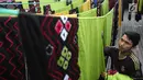 Seorang pekerja menjemur kain sasirangan di kawasan Banjarmasin, Kalimantan Selatan, Senin (26/3). Kain sasirangan ini merupakan kain adat suku Banjar di Kalimantan Selatan. (Liputan6.com/Immanuel Antonius)