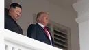Ekspresi Presiden AS Donald Trump (kanan) dan Pemimpin Korea Utara Kim Jong-un saat tampil di balkon Hotel Capella, Pulau Sentosa, Singapura, Selasa (12/6). Pertemuan Donald Trump dan Kim Jong-un membuat sejarah baru bagi perdamaian dunia. (SAUL LOEB/AFP)