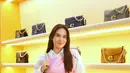 Steffi Zamora tampil manis dan chic dengan memadukan kemeja panjang putih dan mini dress pink sebagai luaran. Gaya feminin-preppy ini semakin sempurna berkat pilihan Twisted Tabby Bag berwarna cream yang serasi. [Dok/FIMELA/Adrian Utama P].