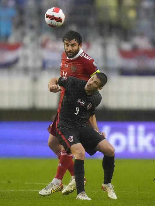 Pemain Kroasia Andrej Kramaric berebut bola dengan pemain Rusia Georgiy Dzhikiya pada pertandingan sepak bola kualifikasi Grup H Piala Dunia 2022 di Stadion Poljud, Split, Kroasia, 14 November 2021. Kroasia menang 1-0. (AP Photo/Darko Bandic)