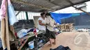 Seorang bocah terlihat ingin mengganti seragam sekolahnya di tenda darurat buatan orangtuanya di Kawasan Bongkaran, Tanah Abang, Jakarta, Rabu (21/1/2015). (Liputan6.com/Miftahul Hayat) 
